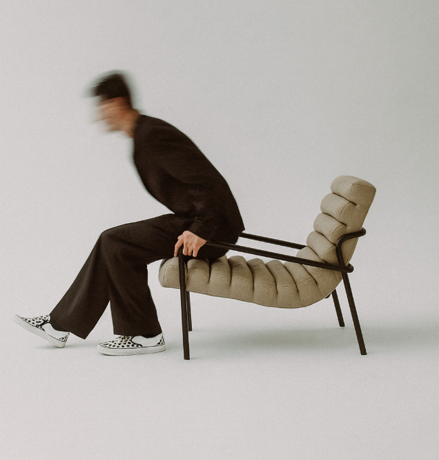 A person rising from a modern chair